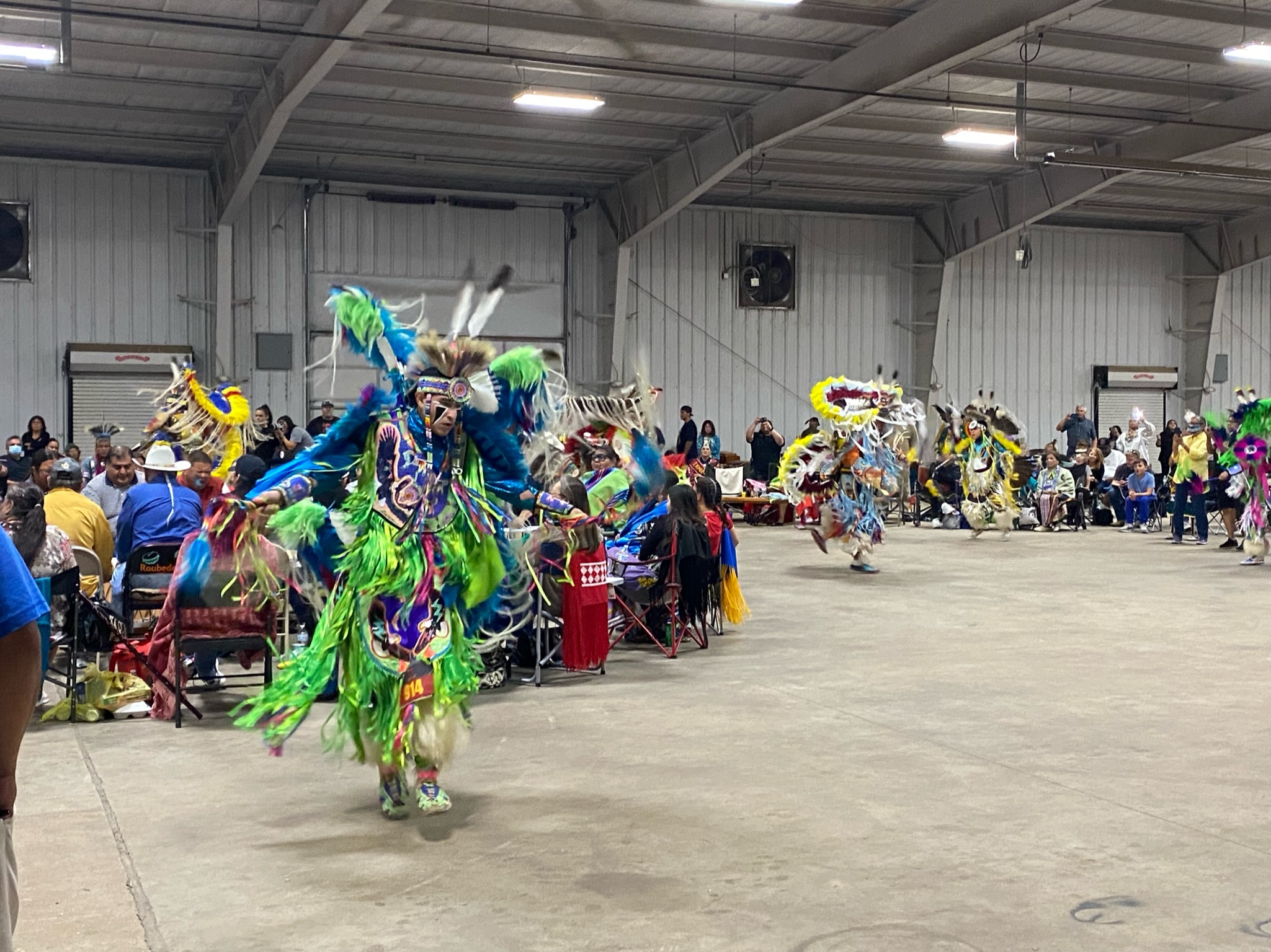 Men’s Fancy dancer in regalia performing at a powwow competition.