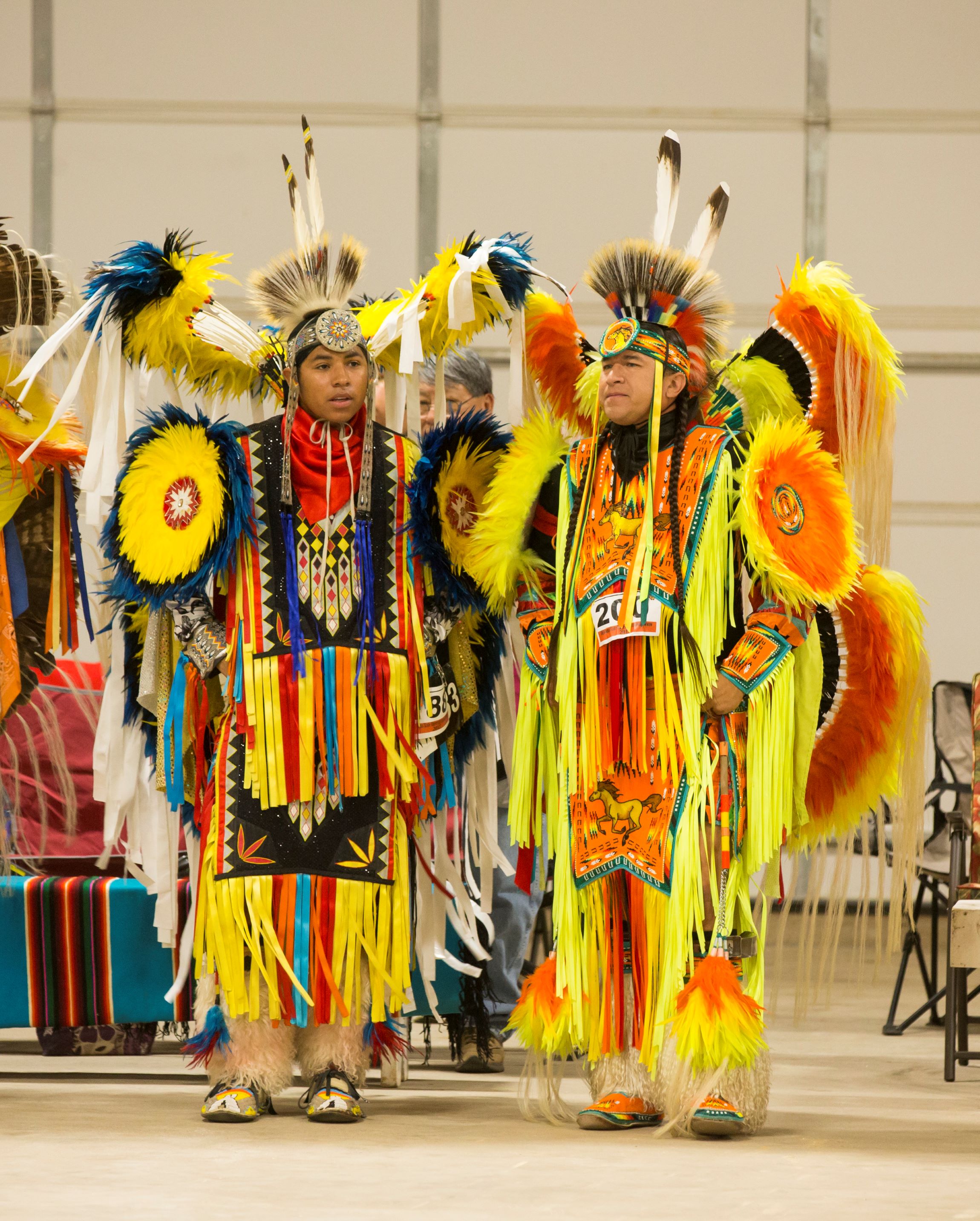 Two Men’s fancy dancer standing next to each other in regalia at OSU powwow competition.