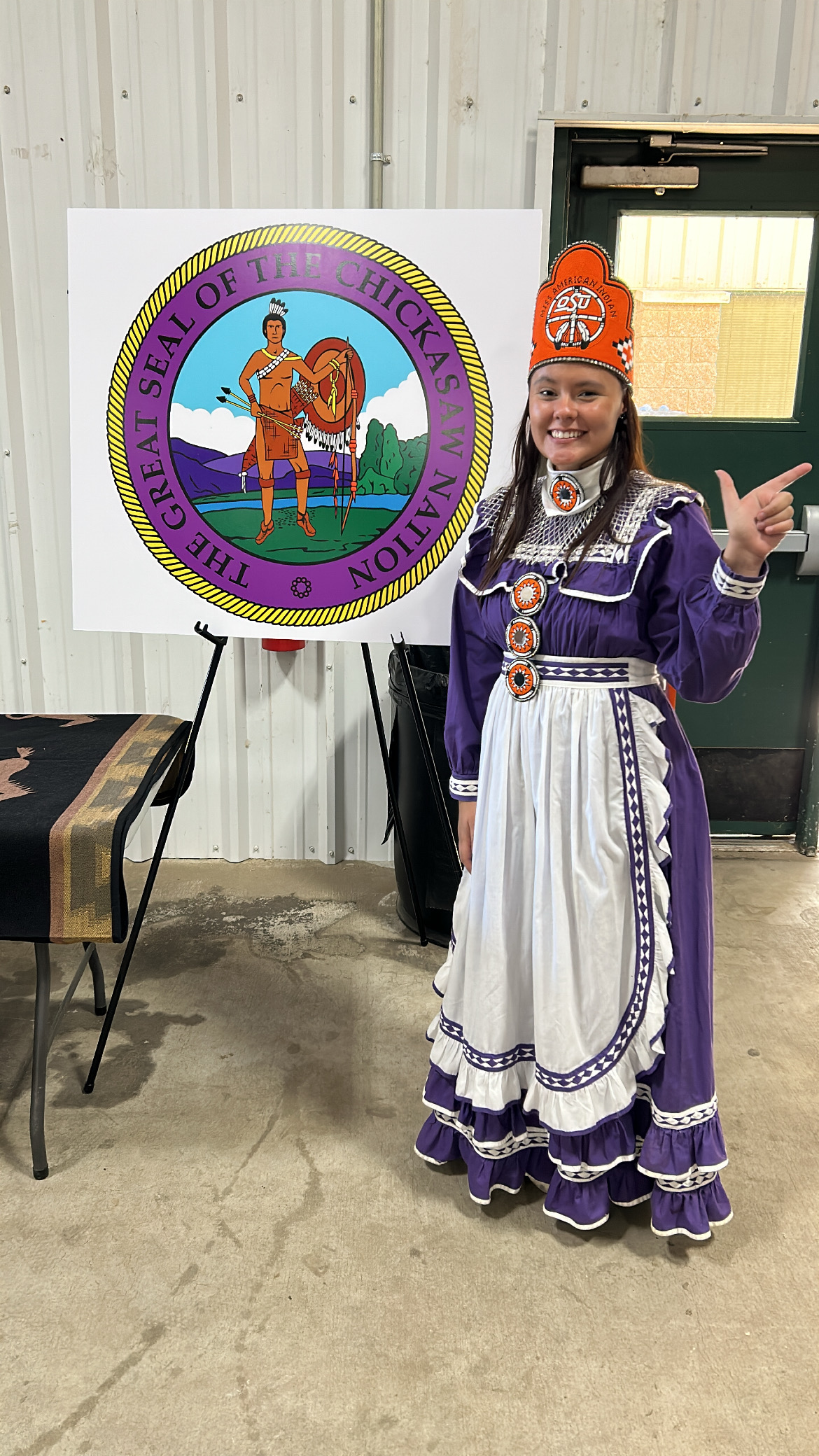 Miss American Indian OSU, Shae McGee, takes a picture next to her nation
